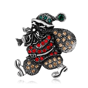 Macro shot of silver alloy Santa Claus brooch with colorful rhinestones and relief texture