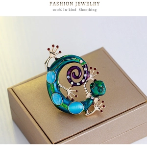 Gros plan sur la broche lézard vintage avec émail bleu et cristaux sur boîte à bijoux