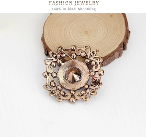Detailed back view of a vintage hollow metal brooch showing the secure safety pin clasp