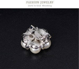 Macro shot of silver metal flower brooch back with pearls and secure safety pin buckle