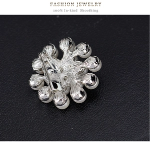Détail de la broche fleur argentée avec perles blanches et fermeture à épingle solide