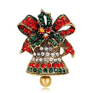 Macro shot of vintage gold Christmas bell brooch with red green rhinestones and pearl