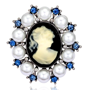 Vintage oval relief brooch with goddess silhouette and blue rhinestones on white background