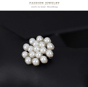Vue macro d'une broche florale avec des perles blanches rondes et des strass étincelants