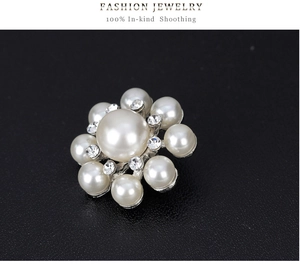 Gros plan d'une élégante broche fleur en argent avec perles blanches et strass brillants