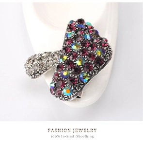 Close-up of vintage mushroom brooch with purple rhinestones and engraved silver alloy