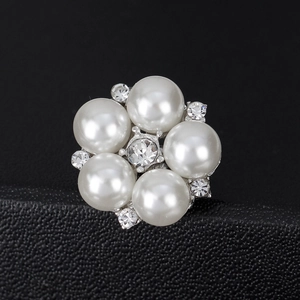 Elegant floral pearl brooch with center crystal on black leather textured pedestal