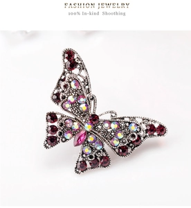 Macro shot of vintage butterfly brooch with sparkling red rhinestones and silver metal filigree