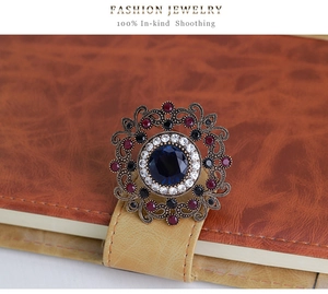 Macro detail of luxury vintage brooch with blue gemstone pinned on leather notebook