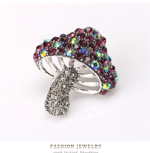 Detailed macro view of mushroom brooch with purple and iridescent crystal inlays