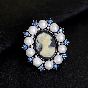 Vintage round cameo brooch with white pearls, blue rhinestones, and silver base