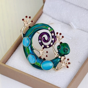 Broche lézard avec pierres œil de chat bleues et émail dans son coffret à bijoux