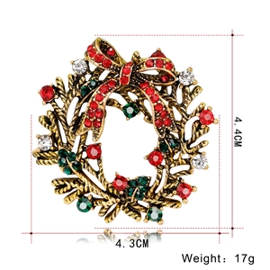 Detailed view of Christmas wreath brooch with colorful rhinestones and gold bow