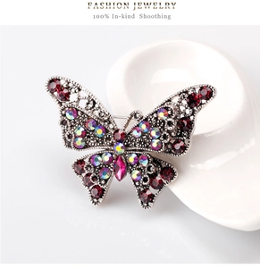 Detailed view of vintage butterfly brooch with red rhinestones and filigree silver wings