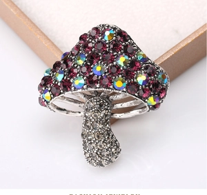 Detailed close-up of mushroom brooch with purple crystals and vintage silver finish