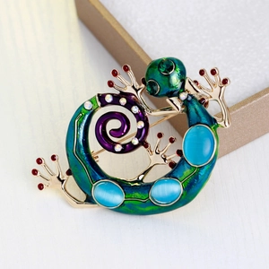 Broche lézard en émail dégradé bleu-vert avec pierre style opale sur un coffret cadeau