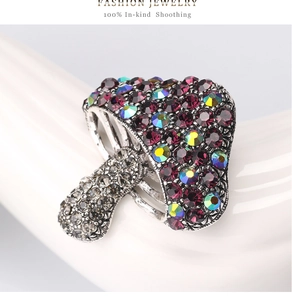 Detailed close-up of a mushroom brooch with purple crystals and silver gills