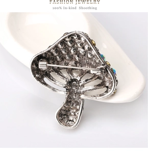 Close-up of the silver mushroom brooch with colorful rhinestones and pin fastener