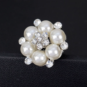 Elegante spilla floreale con perle e strass scintillanti su supporto in pelle nera