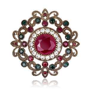 Vintage bohemian luxury hollowed-out brooch with red gemstone and diamond accents
