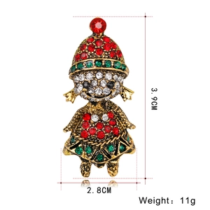 Close-up of Christmas girl brooch in gold finish with red and green rhinestones