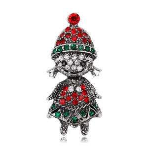 Macro shot of a vintage silver girl brooch with red and green rhinestones