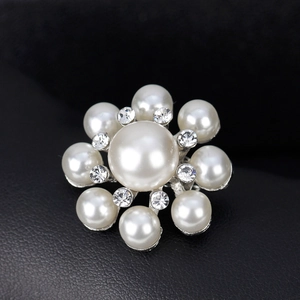 Élégante broche fleurie avec perles blanches et strass brillants sur monture argentée