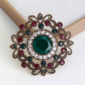 Vintage hollow brooch with large green stone and colorful crystals in bronze finish