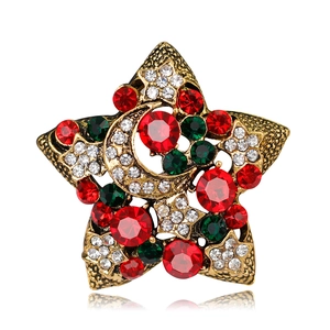 Detailed macro view of vintage star and moon brooch with red and green crystals