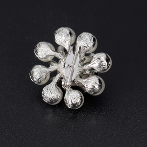 Vue arrière de la broche fleur en perles argentées avec épingle de sûreté en métal