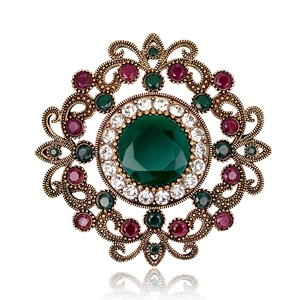 Vintage luxury hollow brooch with green gemstone and diamond accents in antique gold