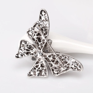 Vintage style butterfly brooch with rhinestone and hollow carved back details in retro silver