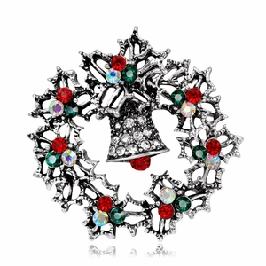 Macro detail of Christmas wreath brooch with bells and colorful crystals in vintage silver