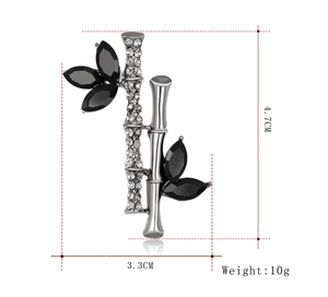 Détail de la broche bambou 4,7cm sur 3,3cm avec cristaux et feuilles noires élégantes