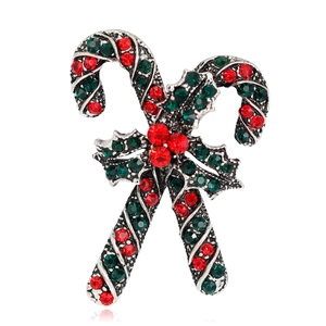 Close-up of Christmas candy cane brooch with red and green rhinestones and holly berries