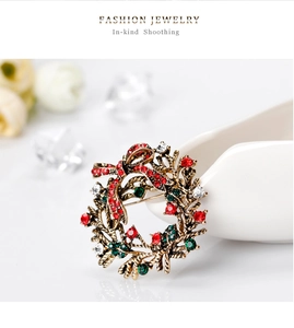 Detailed view of Christmas wreath brooch with sparkling red and green rhinestones