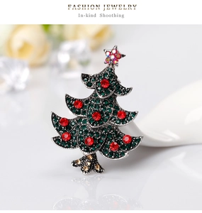 Vue macro d'une broche sapin de Noël en argent vintage sertie de strass verts et rouges