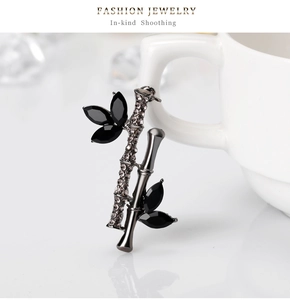 Détail macro d'une broche en bambou avec pierres marquises noires et strass gris