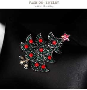 Détail macro d'une broche sapin de Noël avec cristaux colorés sur un fond en cuir noir