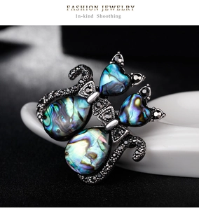 Detailed macro of vintage silver cat brooch with iridescent shell inlay and black stones