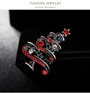 Vue détaillée de la broche sapin de Noël en strass avec étoile rouge sur écrin noir