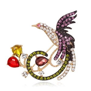 Elegant bird brooch with colorful crystals and pear-shaped red stones in gold alloy