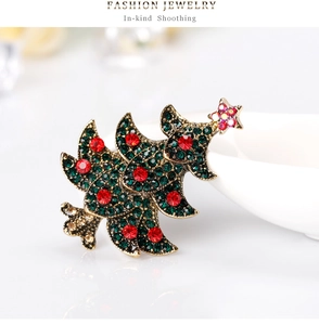 Vue macro détaillée d'une broche sapin de Noël dorée sertie de strass rouges et verts