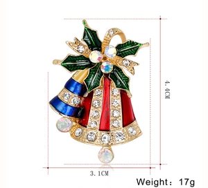 Détail d'une broche cloche de Noël de 4,4 cm x 3,1 cm en émail rouge et bleu et cristaux