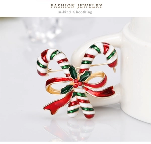 Detailansicht der goldenen Weihnachts-Zuckerstangen-Brosche mit Emaille und roter Schleife