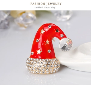 Detailed close-up of a red enamel Christmas hat brooch with sparkling rhinestones and gold stars