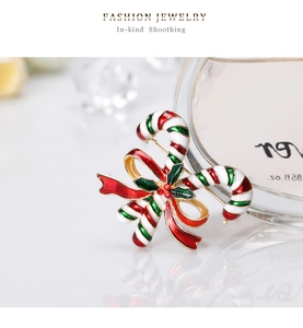 Detail der Weihnachts-Zuckerstangen-Brosche mit roter Schleife und Stechpalmen-Emaille