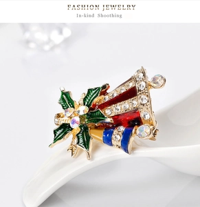 Vue macro d'une broche cloche de Noël plaquée or avec émail rouge bleu et cristaux