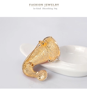 Detailed back view of a gold Christmas brooch featuring a safety pin and dot texture