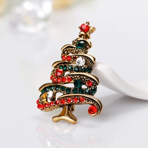 Broche sapin de Noël vintage dorée avec strass rouges, verts et blancs sur fond blanc